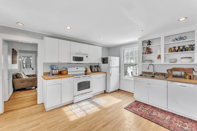 kitchen with sink, light wood-type flooring, white cabinets, crown molding, and white appliances