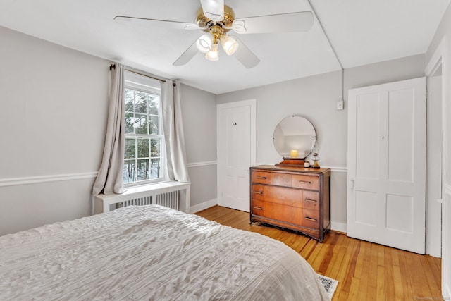 bedroom with ceiling fan, radiator, and light hardwood / wood-style floors