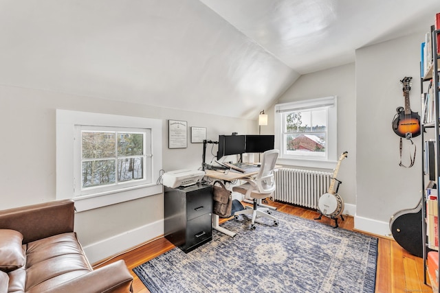 office featuring vaulted ceiling, radiator, and hardwood / wood-style floors