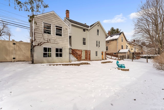 view of snow covered rear of property