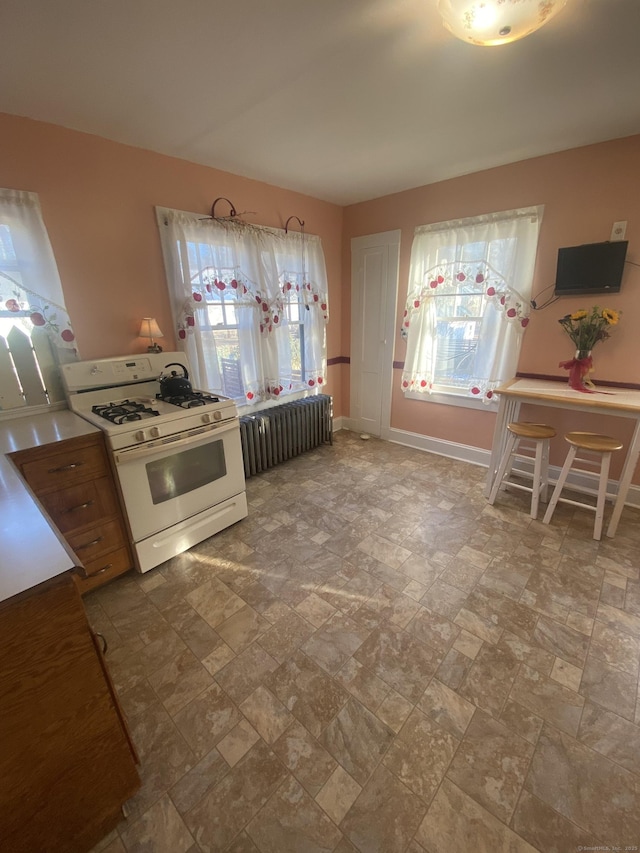 kitchen featuring white range with gas cooktop and radiator