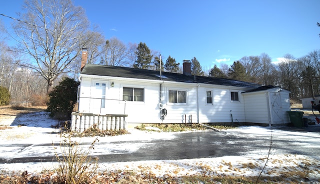 view of snow covered back of property