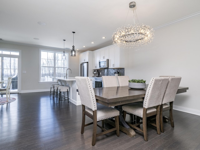 dining area with dark hardwood / wood-style flooring, sink, crown molding, and an inviting chandelier