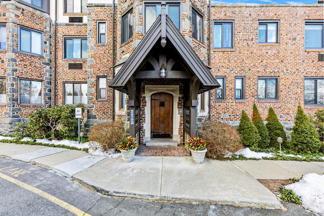 entrance to property featuring brick siding