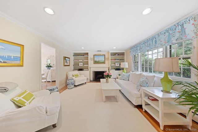 living area with light wood finished floors, a fireplace, crown molding, and recessed lighting