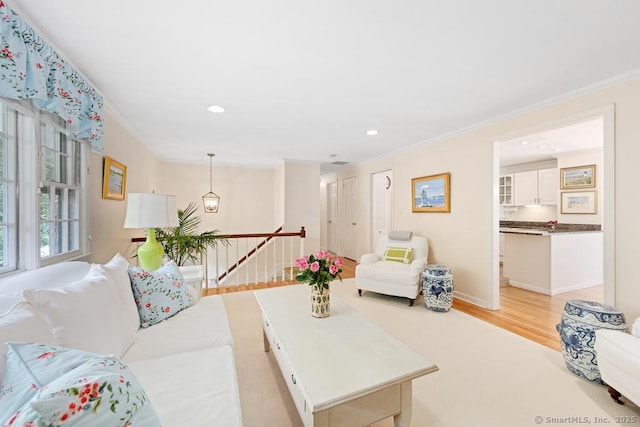 living area featuring light wood-type flooring, baseboards, ornamental molding, and recessed lighting