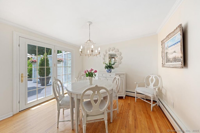 dining space featuring a chandelier, light wood-style floors, crown molding, and baseboards