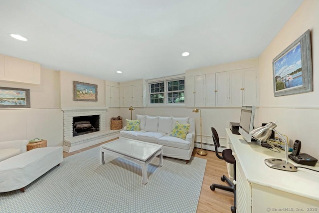 living area featuring recessed lighting, a brick fireplace, and light wood finished floors