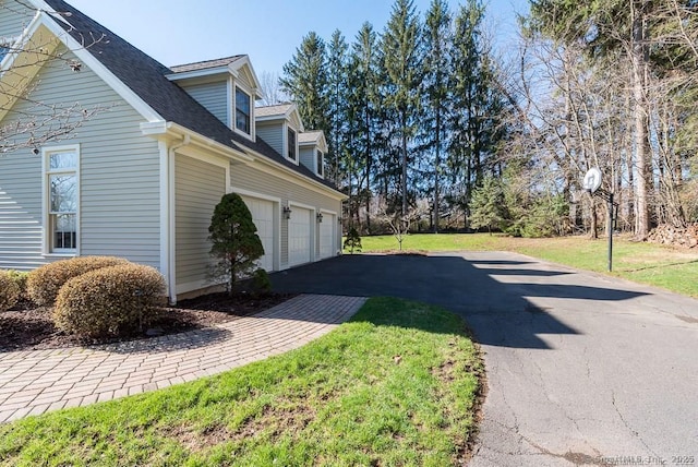 view of side of home with a garage and a yard