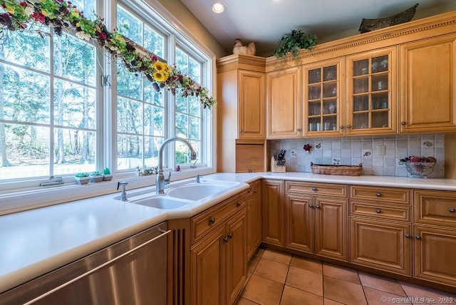 kitchen featuring a wealth of natural light, sink, stainless steel dishwasher, and light tile patterned floors