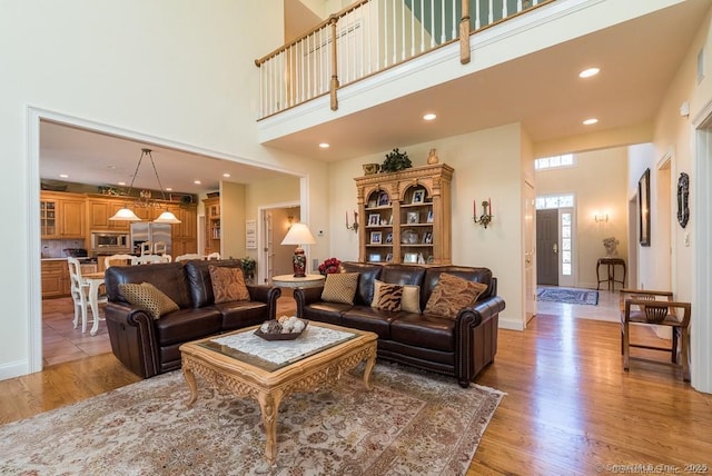 living room featuring a high ceiling and light wood-type flooring