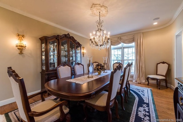 dining area with ornamental molding, a chandelier, and hardwood / wood-style floors