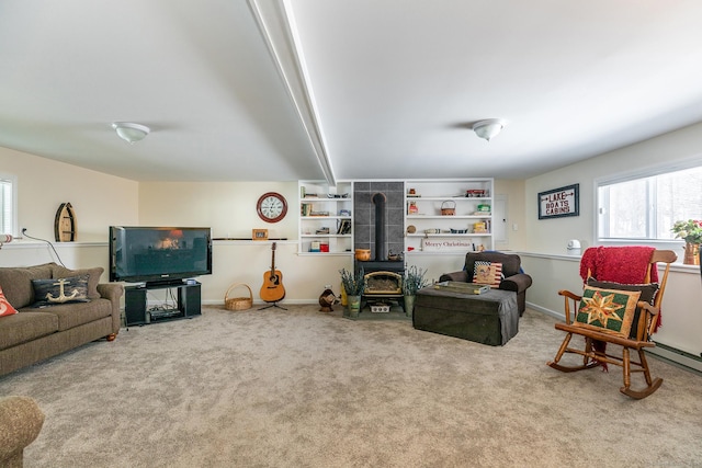 living area with baseboards, a wood stove, and light colored carpet