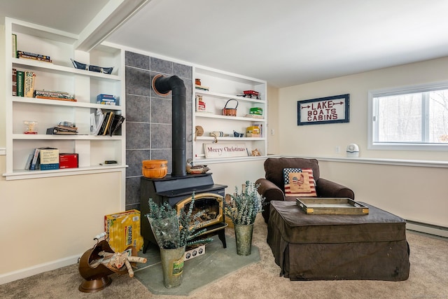 living area featuring carpet floors, a wood stove, and built in shelves