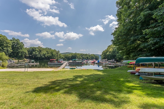 surrounding community featuring a yard, a boat dock, and a water view