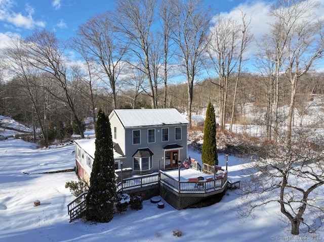 snow covered house with a wooden deck