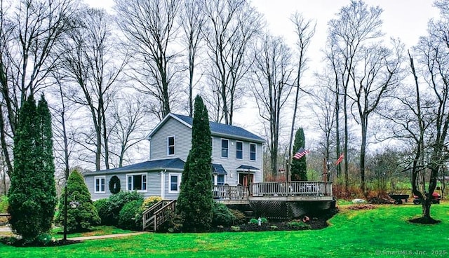 back of house with a wooden deck and a lawn