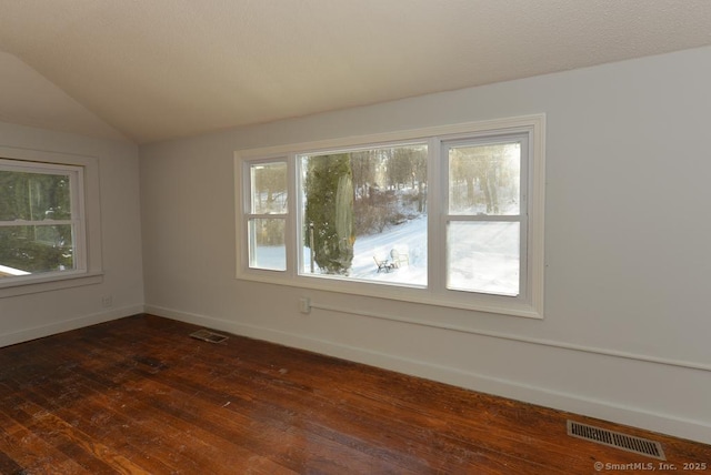 empty room featuring dark wood-type flooring and vaulted ceiling