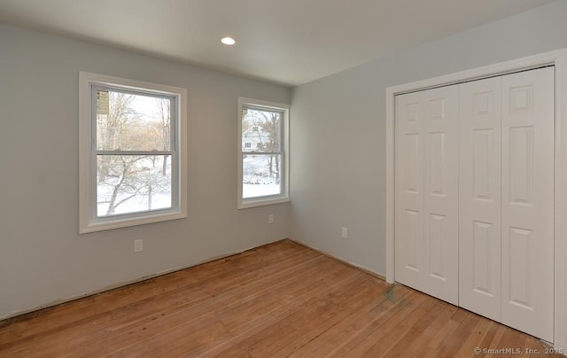 unfurnished bedroom featuring light hardwood / wood-style floors and a closet