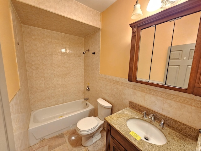 full bathroom featuring vanity, toilet, tiled shower / bath combo, and tile walls