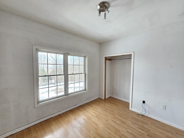 unfurnished bedroom featuring light hardwood / wood-style floors and a closet