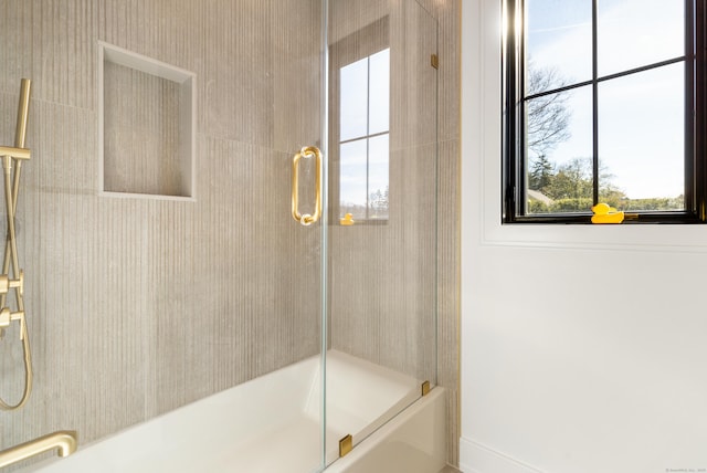 bathroom with shower / bath combination with glass door