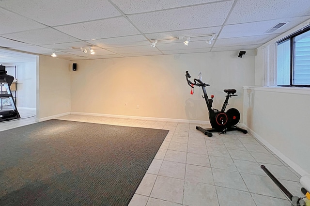 exercise room with track lighting, a drop ceiling, and light tile patterned flooring