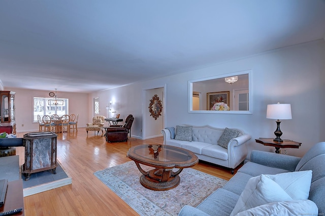 living room featuring a notable chandelier and light wood-type flooring