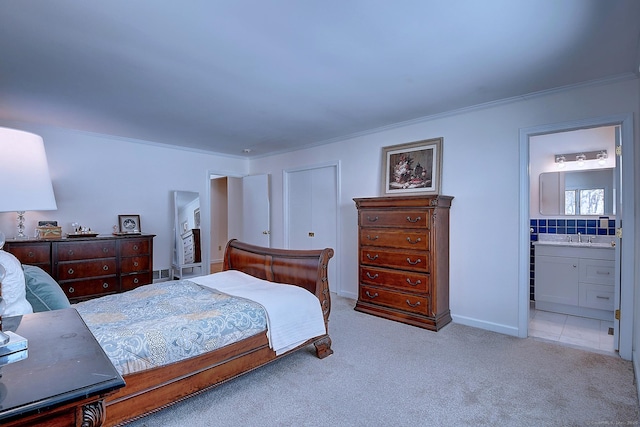 bedroom featuring crown molding, sink, light colored carpet, and ensuite bath