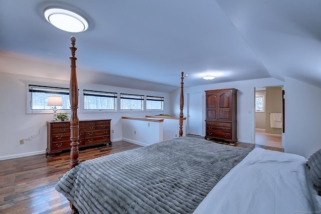 bedroom featuring multiple windows, dark wood-type flooring, and vaulted ceiling