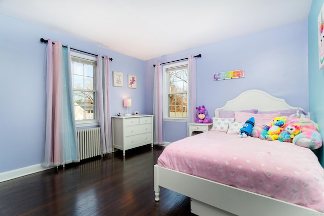 bedroom with multiple windows, radiator heating unit, and dark hardwood / wood-style floors