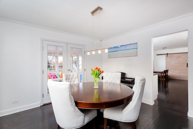 dining room featuring ornamental molding, a barn door, dark hardwood / wood-style floors, and french doors