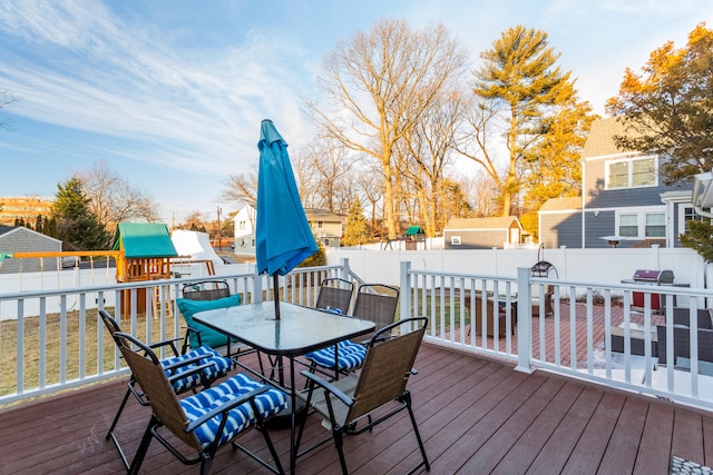 deck featuring area for grilling, a yard, and a playground