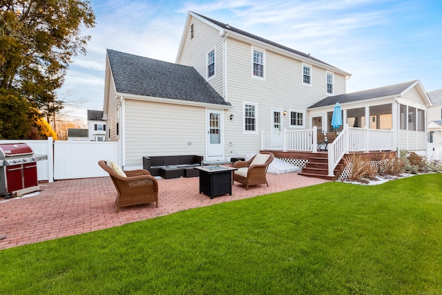 back of property featuring a wooden deck, a yard, an outdoor living space with a fire pit, and a patio area