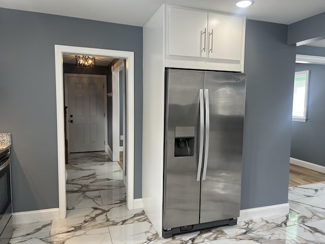 kitchen featuring baseboards, white cabinets, stainless steel fridge with ice dispenser, marble finish floor, and recessed lighting