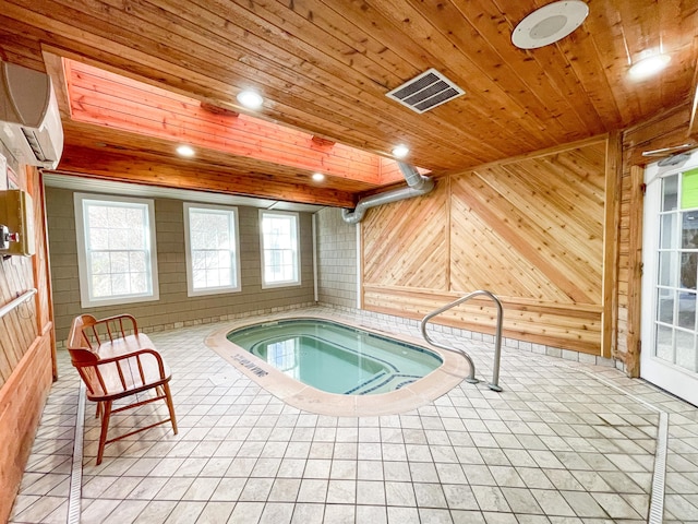 view of swimming pool with an indoor hot tub and a wall mounted AC