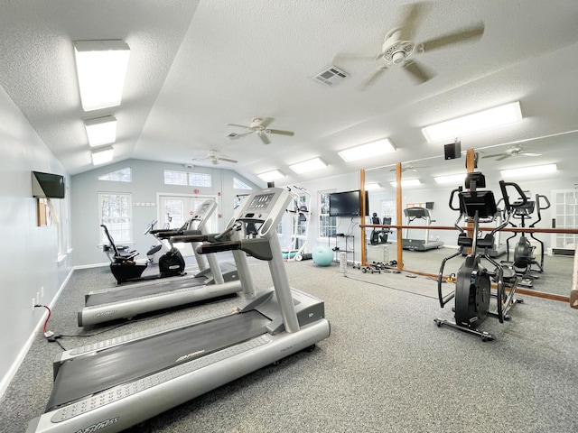 exercise room featuring baseboards, visible vents, lofted ceiling, ceiling fan, and a textured ceiling