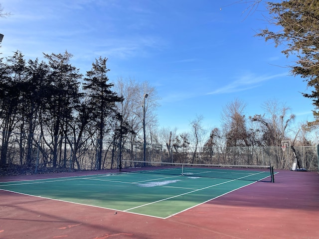 view of tennis court featuring fence