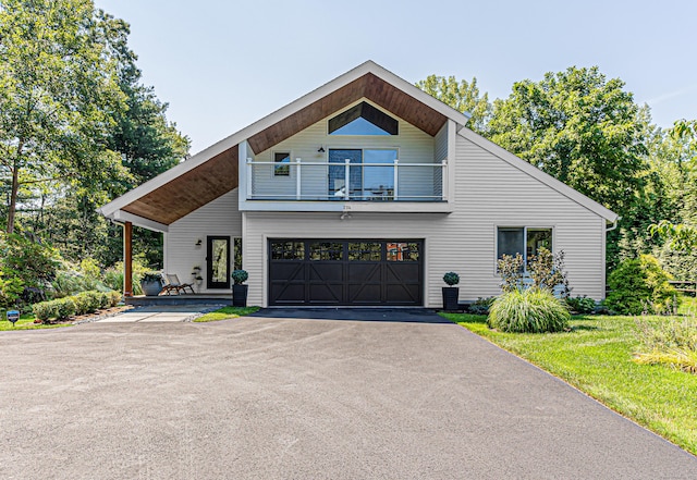 contemporary home with a balcony, a garage, and a front lawn