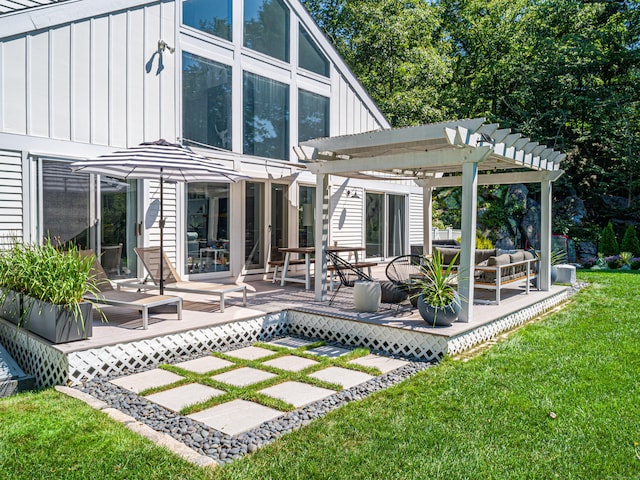 rear view of house featuring outdoor lounge area, a pergola, a deck, and a lawn