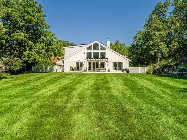 back of house featuring a yard, a patio area, and a pergola