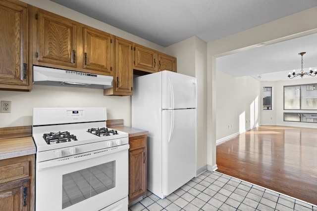 kitchen featuring hanging light fixtures, a chandelier, white appliances, and light tile patterned floors