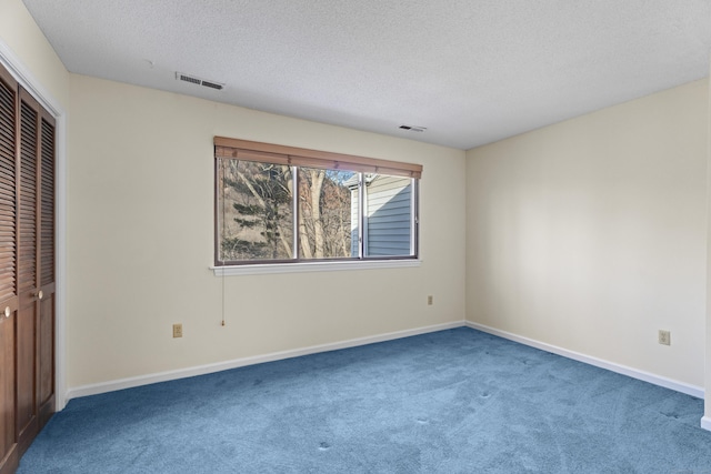 unfurnished bedroom featuring a closet, carpet, and a textured ceiling