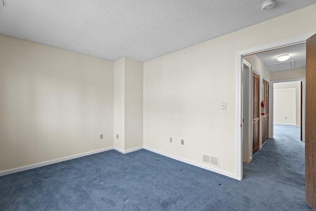 carpeted empty room with a textured ceiling