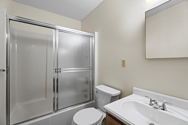 full bathroom with vanity, a textured ceiling, shower / bath combination with glass door, and toilet