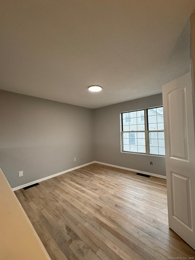 spare room featuring light hardwood / wood-style flooring