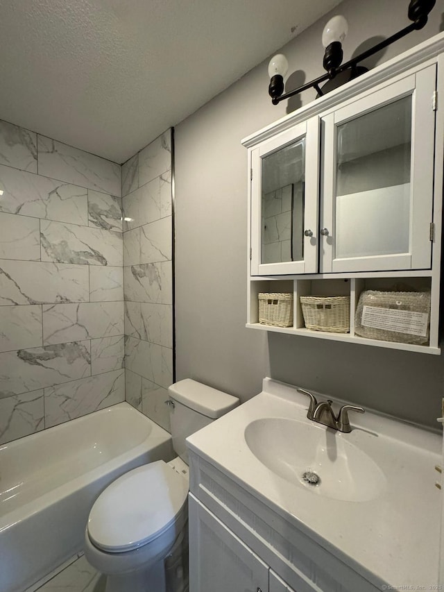 full bathroom featuring vanity, a textured ceiling, toilet, and tiled shower / bath