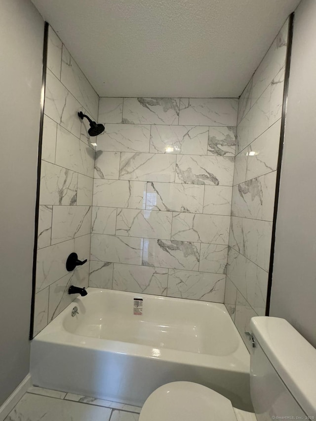 bathroom with tiled shower / bath combo, toilet, and a textured ceiling