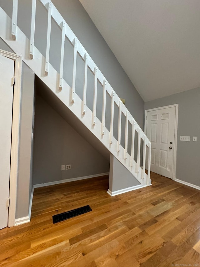 staircase with hardwood / wood-style flooring