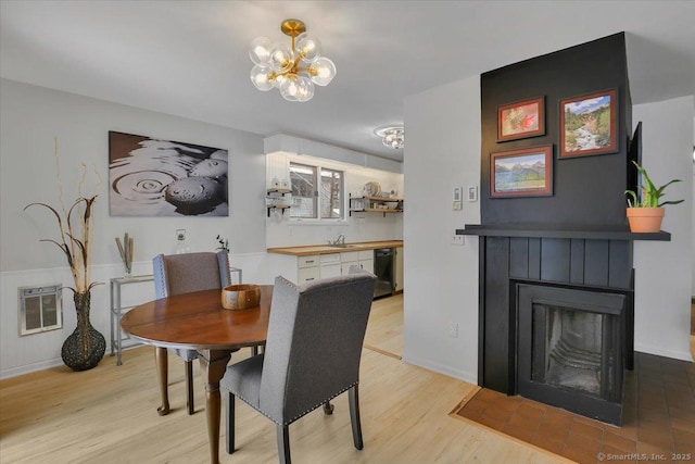 dining room with sink, a chandelier, light hardwood / wood-style floors, and heating unit